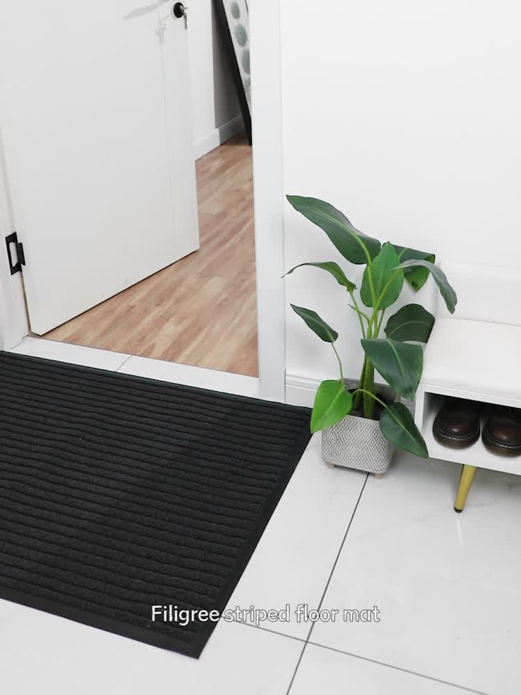 Black low-profile indoor outdoor doormat with tight textured pile and flat edge
