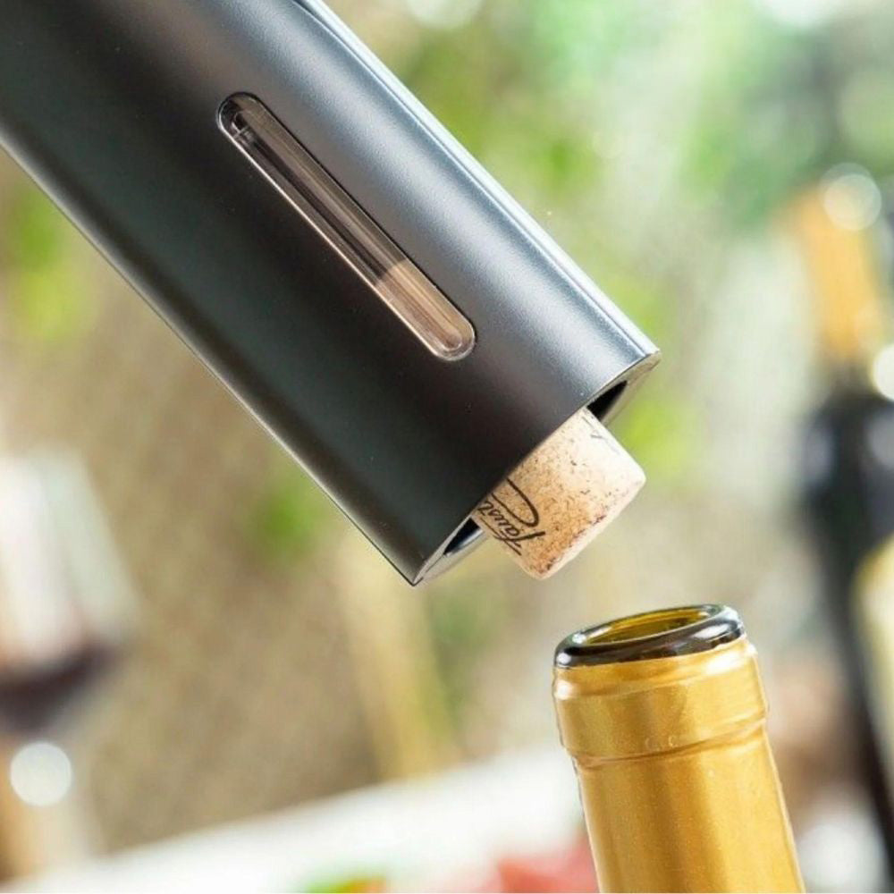 Electric wine opener tip inserted into a cork at the top of a bottle