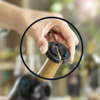 Hand holding the electric wine opener while pulling a cork from a bottle