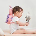 Pink padded head protector backpack with adjustable straps on a baby