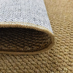 Close-up of jute-look doormat edge with beige pile and white non-slip backing.