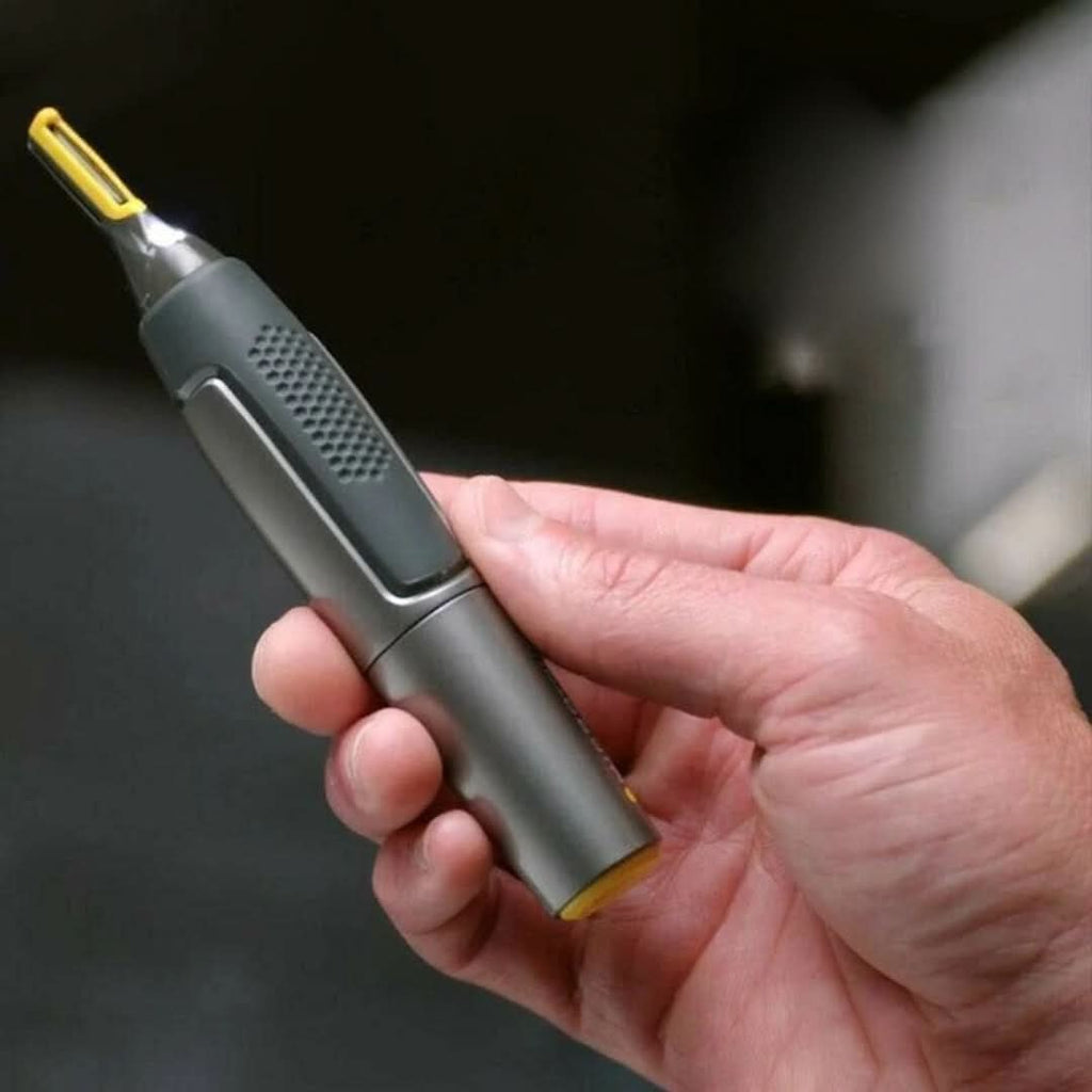 Hand holding cordless trimmer with yellow cutting head, dark gray textured grip