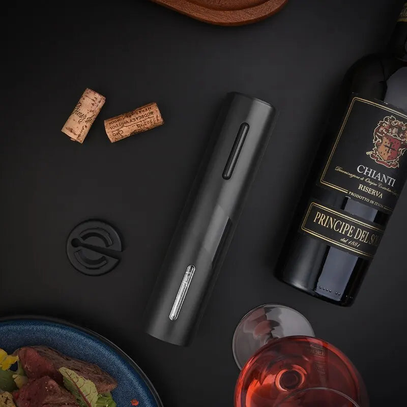 Electric wine opener on countertop with corks, wine bottle, and foil cutter