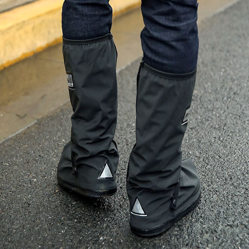 Black reusable overshoe covers with cuff and triangular logo, worn over boots