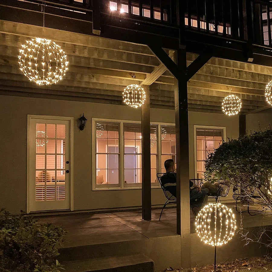 Warm white LED light-up sphere decorations on patio, including hanging and standing spheres