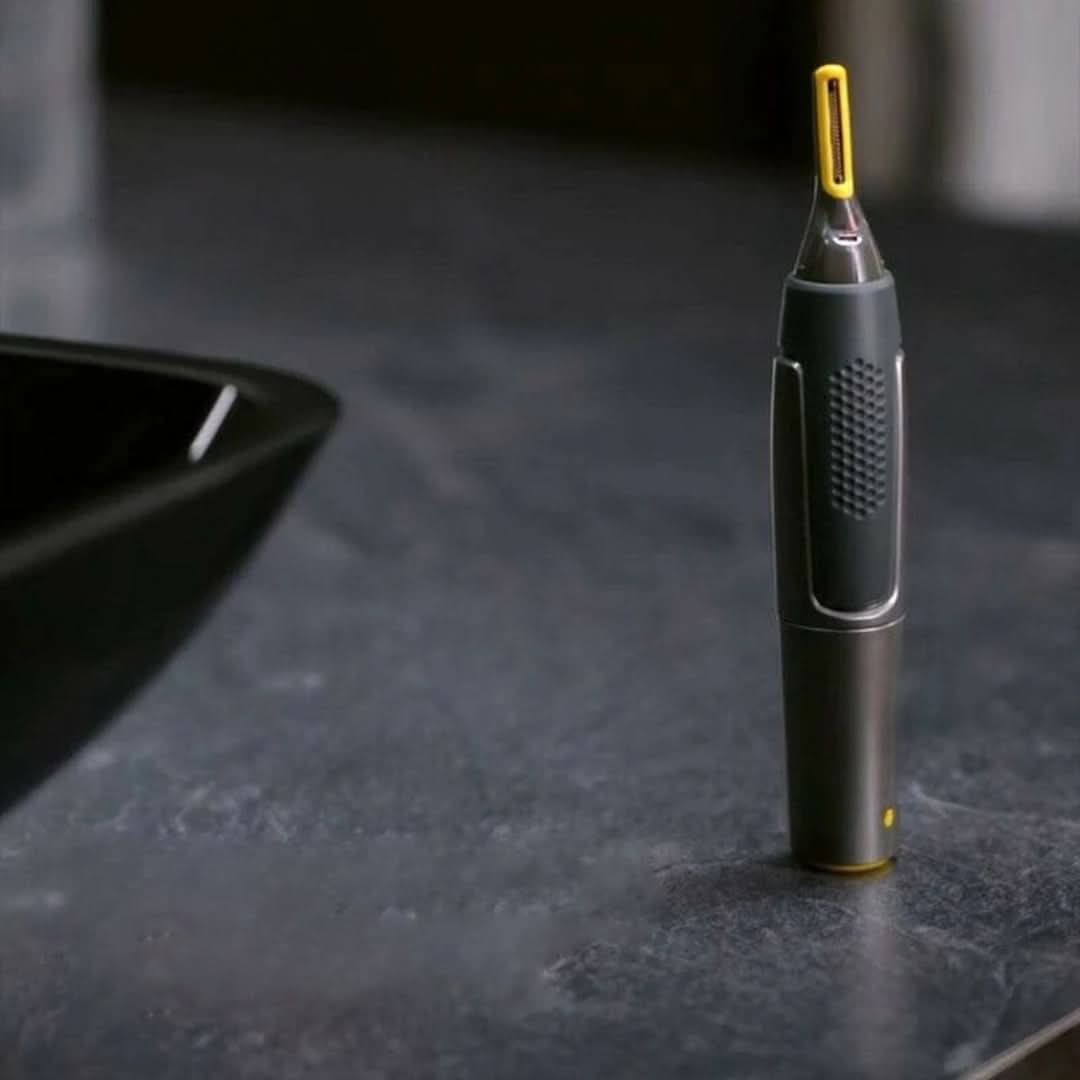 Cordless detail trimmer standing upright, black body with textured grip and yellow tip