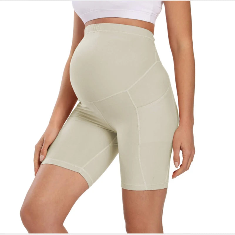 Cream maternity bike-length leggings with high waist and stitched seam paneling