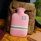 Pink knit hot water bottle cover with striped bands and top stopper label
