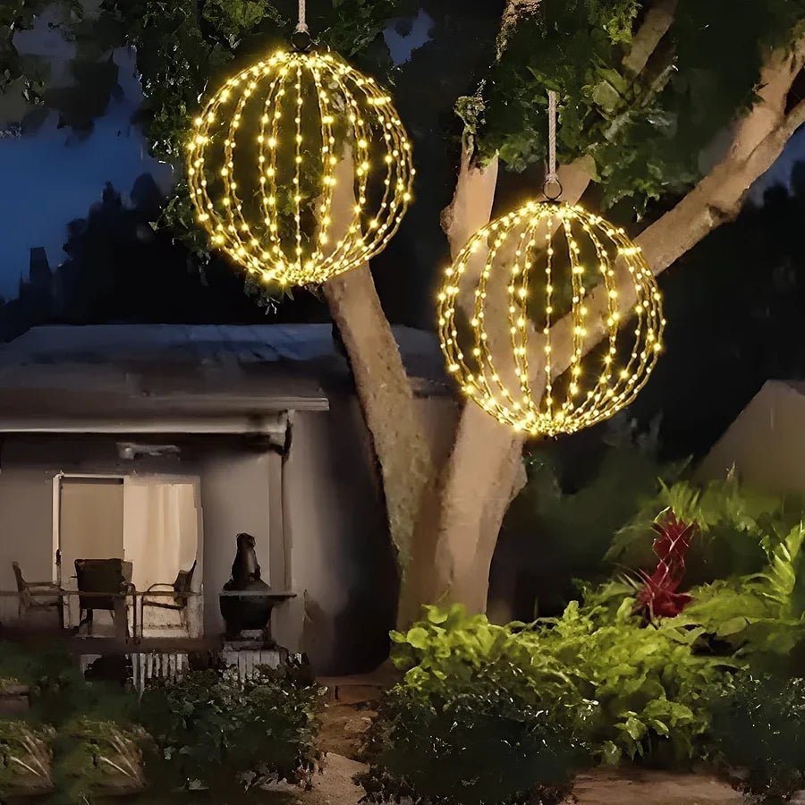 Warm white LED hanging wire sphere decorations among trees and shrubs