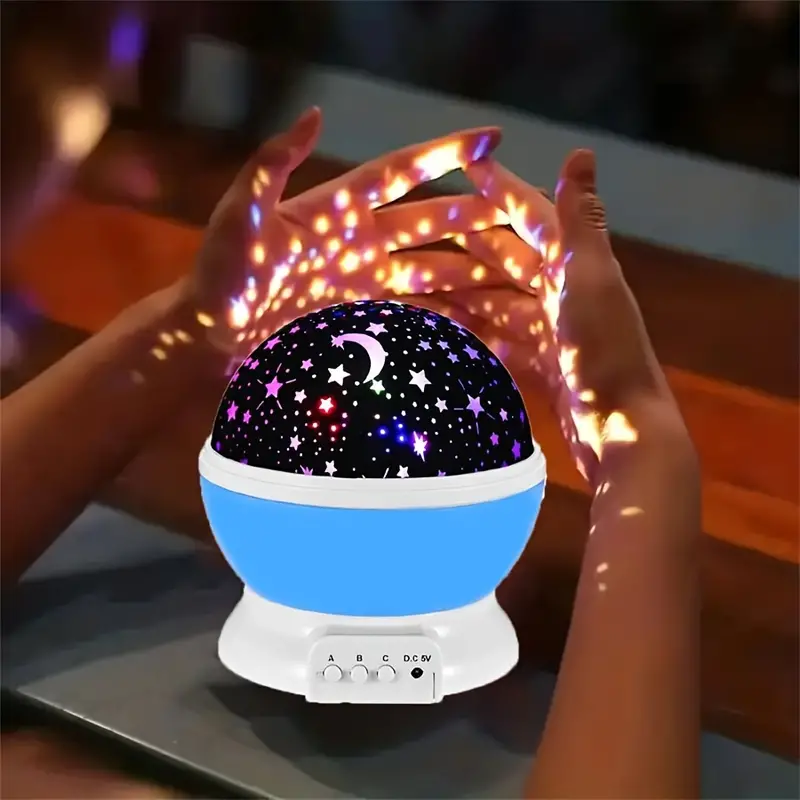 Starry sky night light with glowing black star dome and blue base on a table