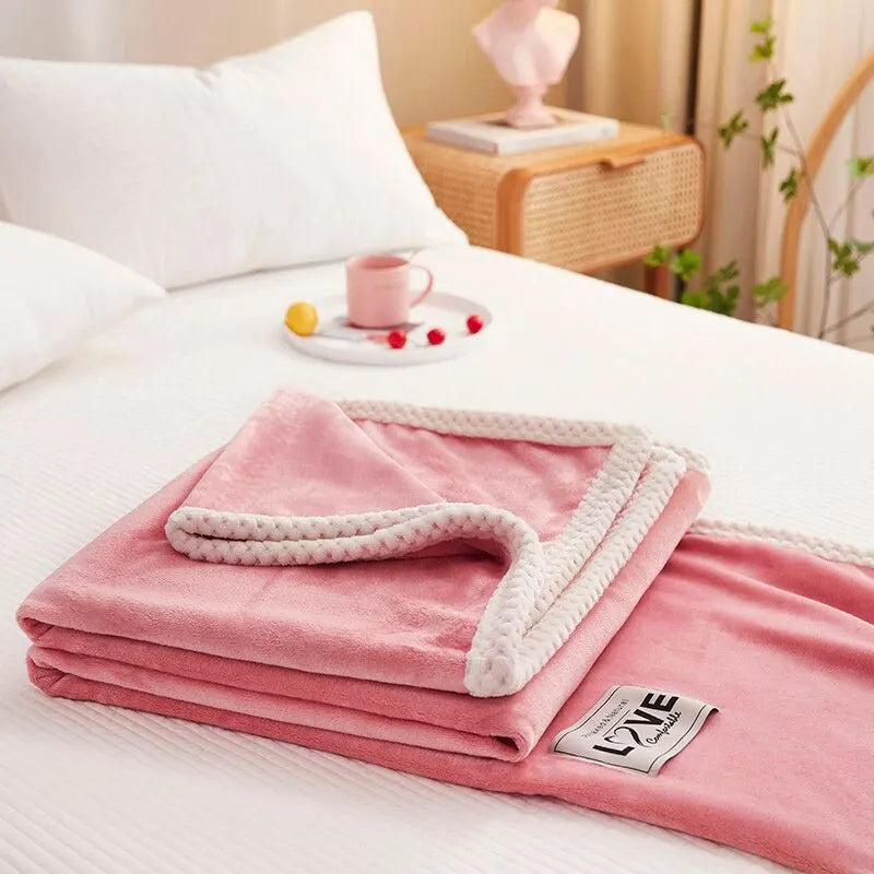 Pink flannel fleece throw blanket folded with white textured border and LOVE logo patch