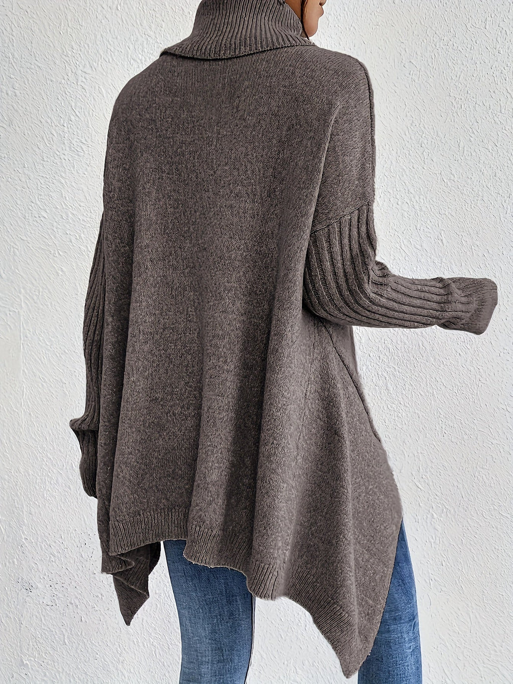 Back view: women’s loose turtleneck sweater, taupe-gray knit with ribbed cuffs.