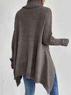 Back view: women’s loose turtleneck sweater, taupe-gray knit with ribbed cuffs.