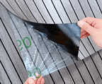 Peel-and-stick wood slat wall panel backing film being removed, grid lines visible
