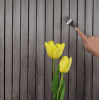 Gray wood slat wall panel surface, hand roller smoothing peel-and-stick adhesive
