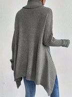 Back view: women’s loose turtleneck sweater, dark gray knit with ribbed cuffs.
