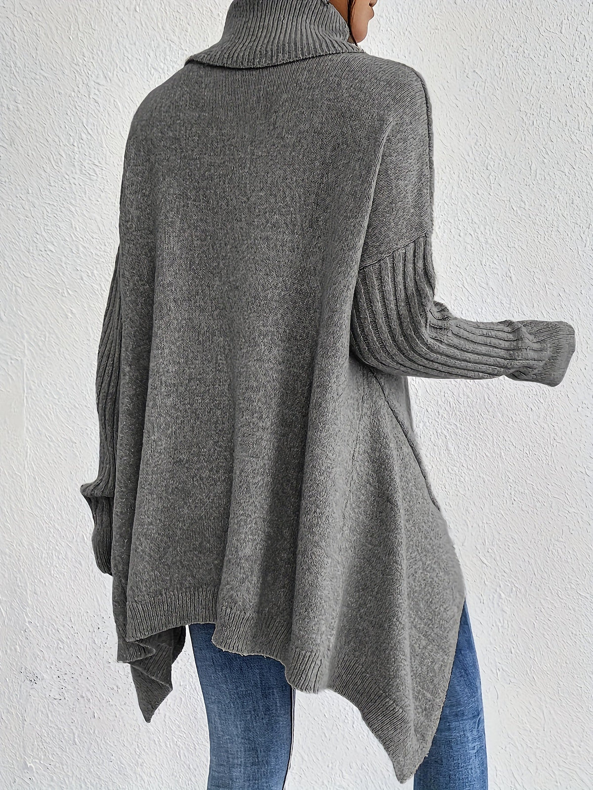 Back view: women’s loose turtleneck sweater, dark gray knit with ribbed cuffs.