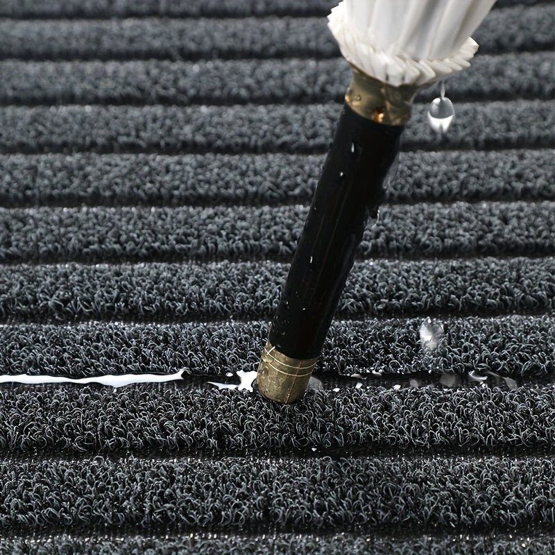 Black doormat texture close-up with dense ribbed stripes for scraping dirt