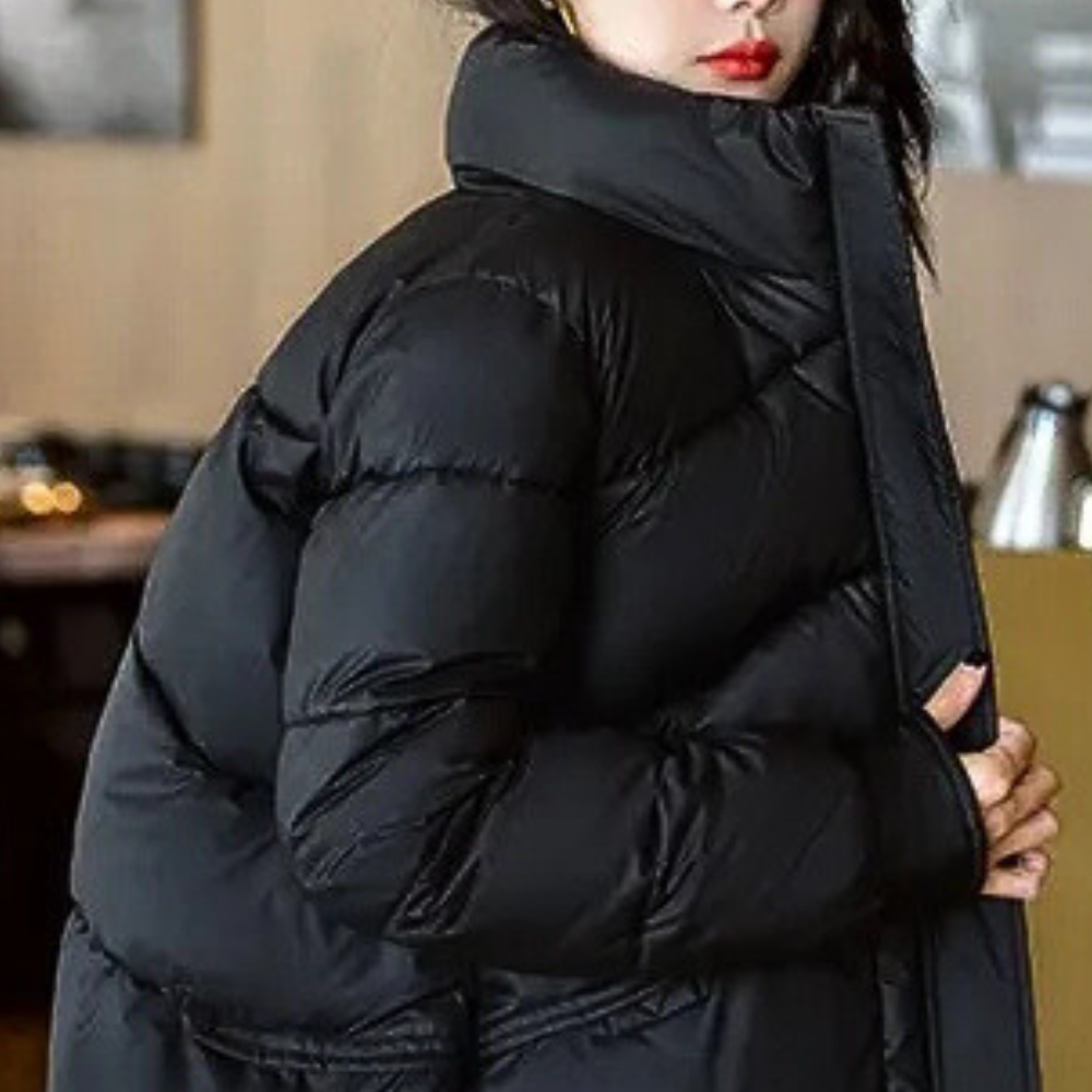 Women’s black puffer jacket with high stand collar and quilted sleeves, side view