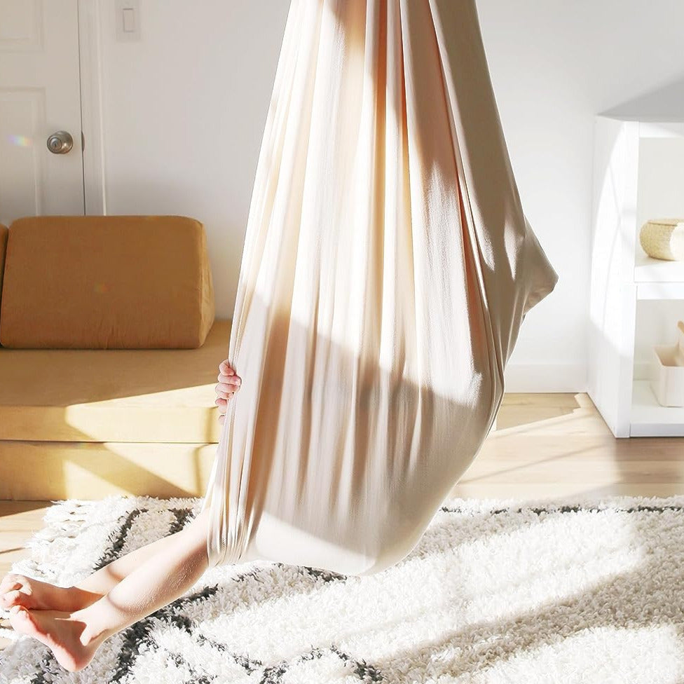Cream kids' cotton hammock swing cocoon hanging with open lounging end.