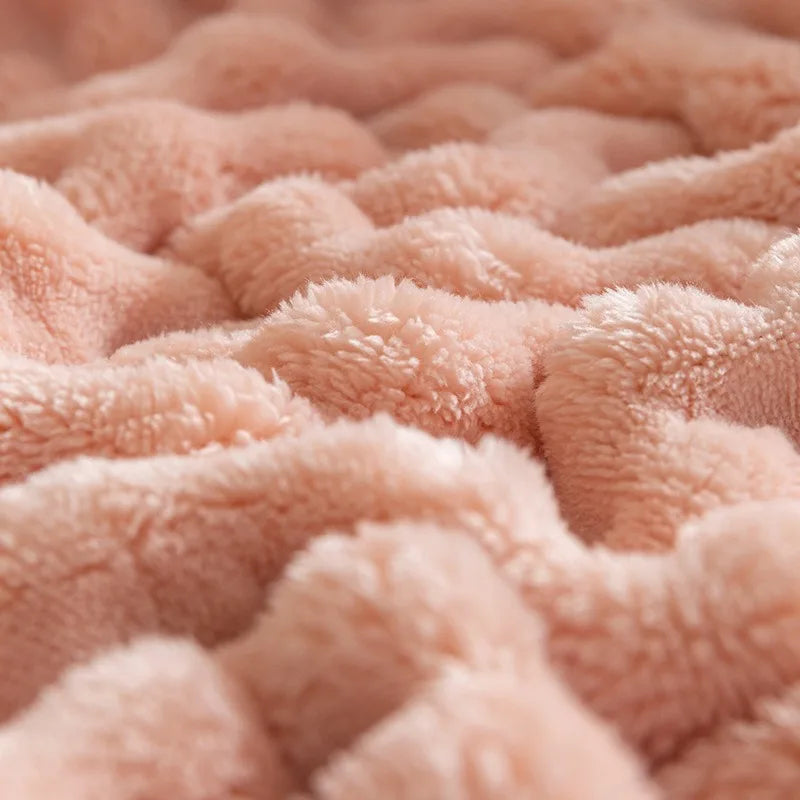 Bubble-texture fleece blanket in soft coral pink with plush ridged bubble pattern (close-up)