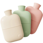 Three large hot water bottles in natural beige, green, and pink colors