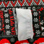 Kissmas sweater inner hem with white label and black/red holiday knit pattern.