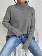 Women’s loose turtleneck sweater, medium gray knit with ribbed cuffs and hem.