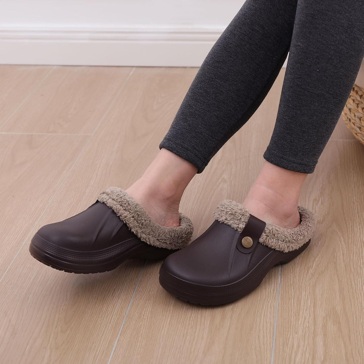 Dark slip-on clogs with beige sherpa lining and round button detail