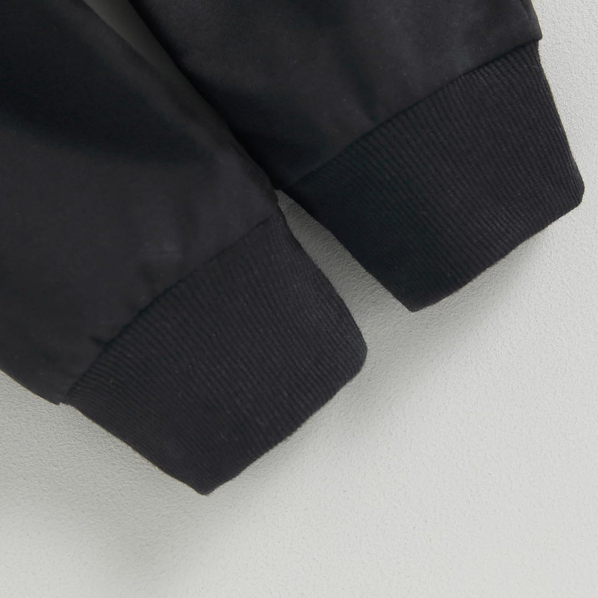 Black knit cuffs on baby stretch pants at pant-leg hem