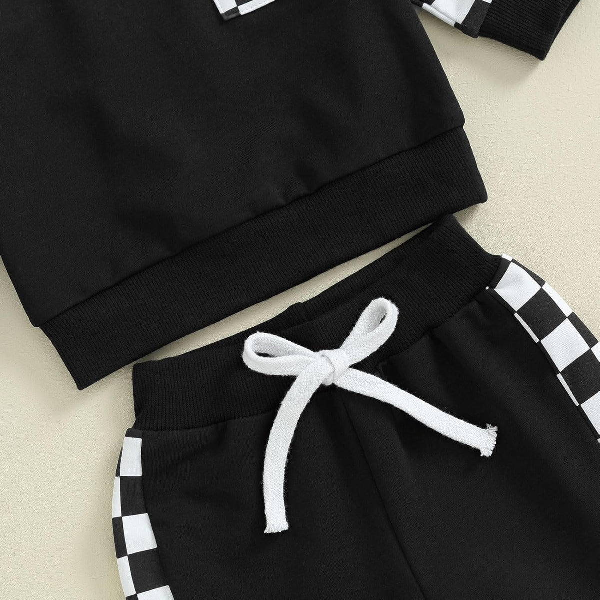 Baby Jogger sweatpants detail: black pants with white check trim and white drawstring tie.