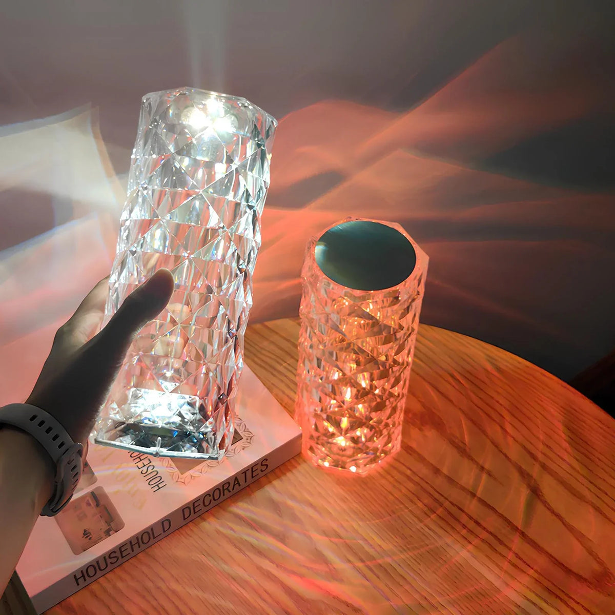 Two faceted crystal table lamps: clear with white glow and orange with red glow.