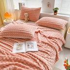 Bubble-texture fleece blanket in soft coral pink with ridged bubble pattern, on couch