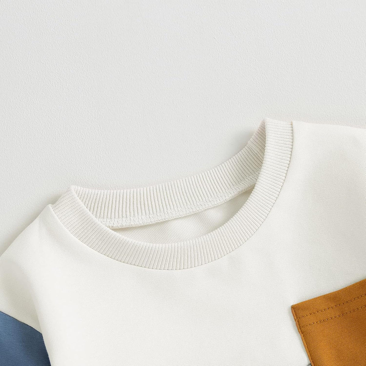 White sweatshirt with ribbed crew neck and tan patch pocket detail