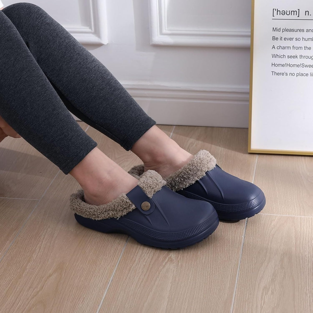 Navy slip-on clogs with plush gray lining, worn indoors on wood floor