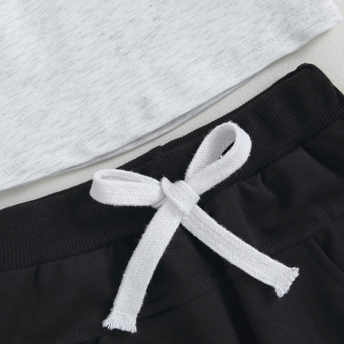 Black pants with white drawstring bow at the waist