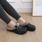 Pair of black plush-lined slip-on clogs worn with socks