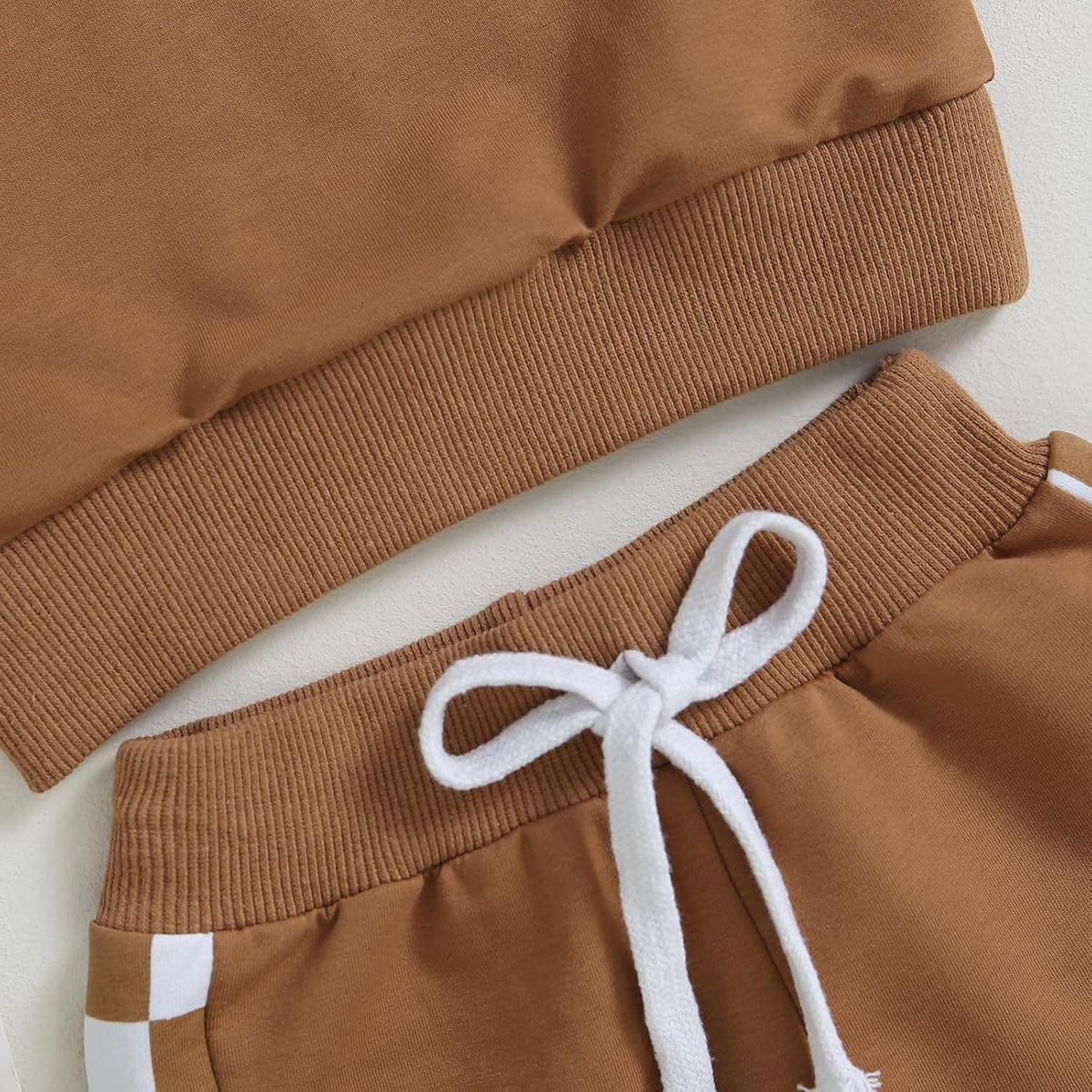 Brown jogger pants with white drawstring and stripe pocket accent
