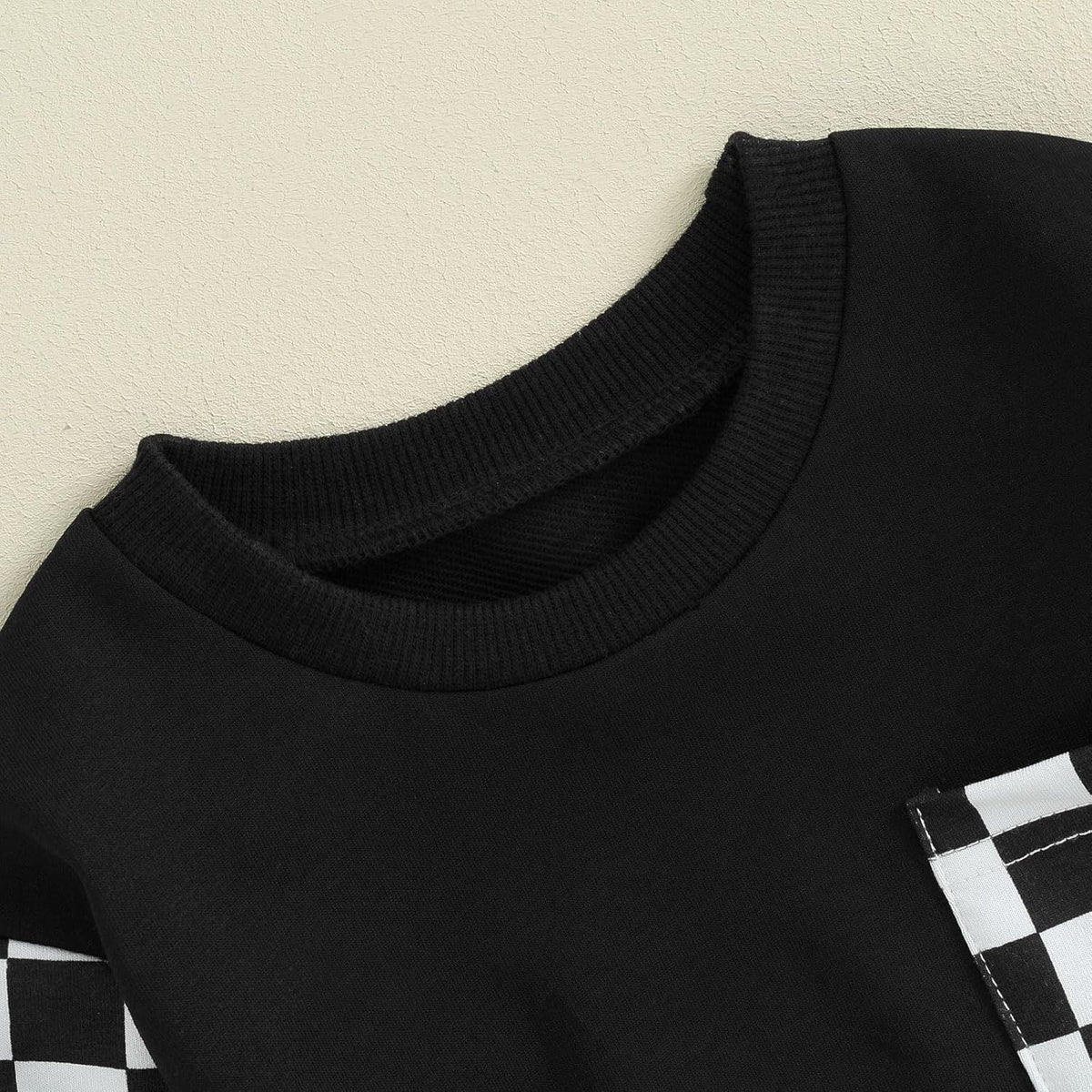 Black baby sweatshirt with ribbed crew neck and white checkered pocket panel