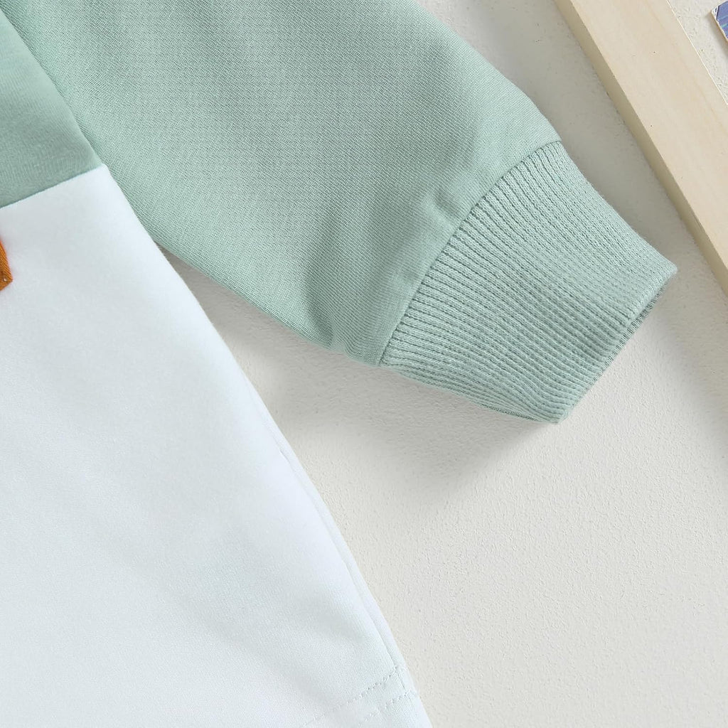Mint sweatshirt sleeve with ribbed cuff detail over white pants