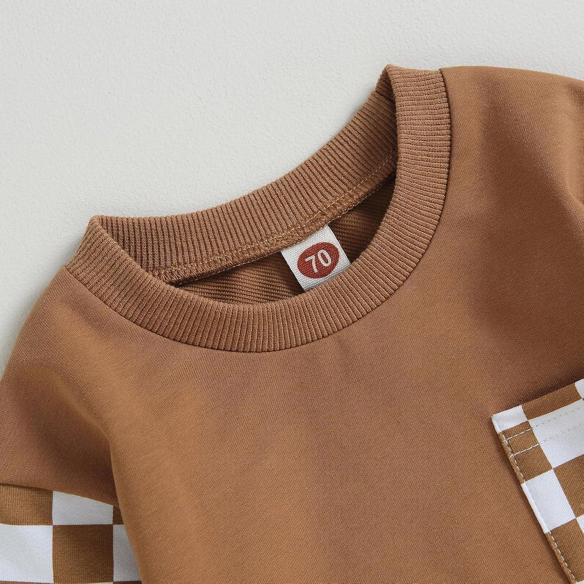 Brown long-sleeve sweatshirt neckline with tag and checkered pocket panel