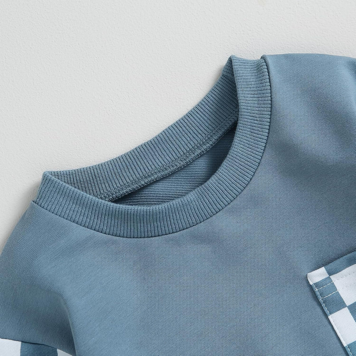Light blue long-sleeve sweatshirt with ribbed crew neck and checkered detail near hem