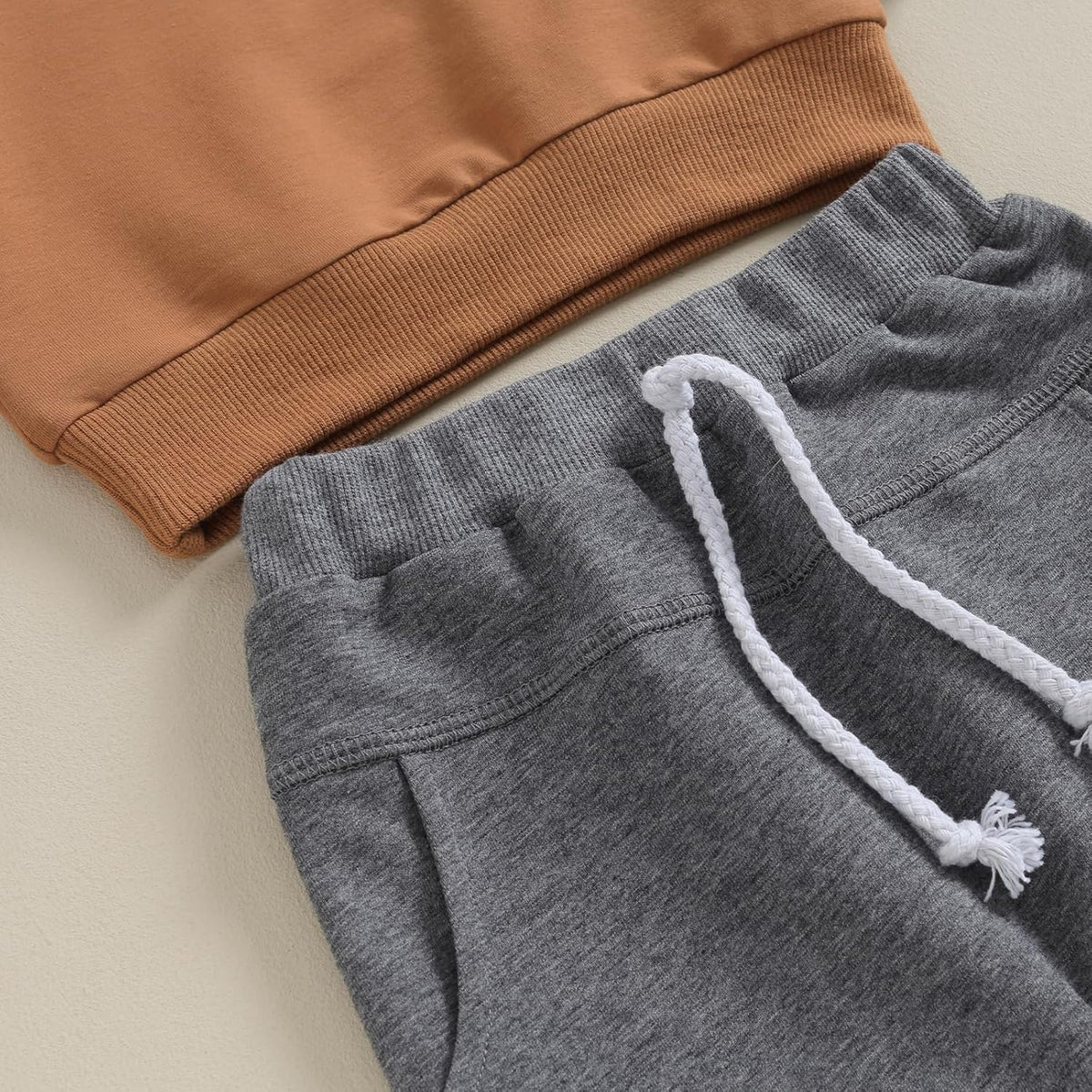 Charcoal gray jogger pants with white drawstring and ribbed waistband