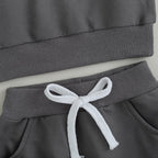 Gray pants waistband with white drawstring and ribbed pant cuffs