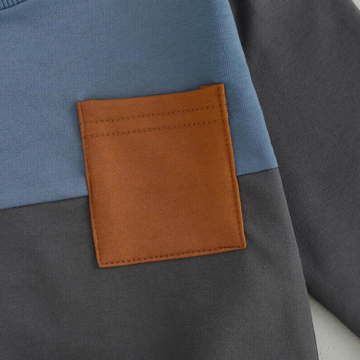 Gray jogger pants with stitched square pocket patch in brown and orange tones