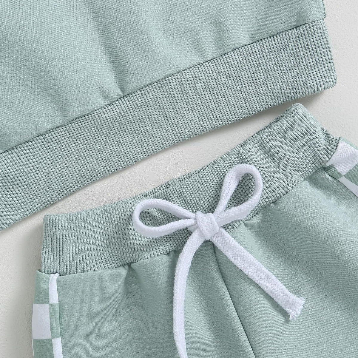 Light blue sweatshirt sleeve cuff and mint jogger waistband with white drawstring