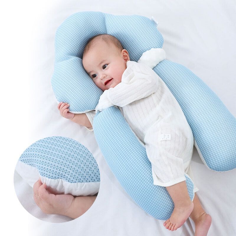 Blue U-shaped baby support cushion with infant lying in the center