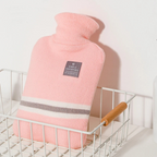 Pink knit hot water bottle cover with striped band and fabric label