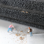 Gray textured low-profile doormat with short-loop pile and small specks at edge