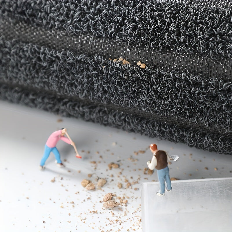 Gray textured low-profile doormat with short-loop pile and small specks at edge